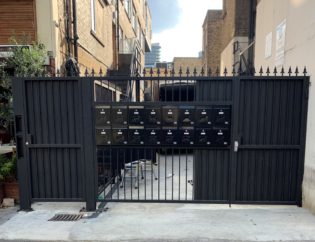Custom black metal security gate installed at a residential property entrance in London.