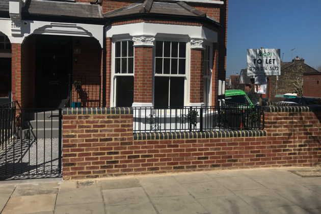 Black metal railings and matching pedestrian gate installed at a residential property in London.