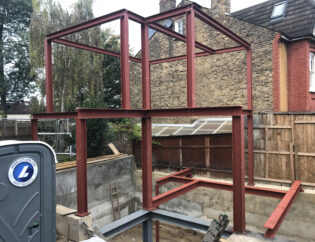 Commercial steel structure frame under construction with fabricated steel beams and columns.