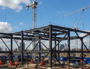 Structural steel fabrication project with a steel frame under construction at a commercial building site in London.